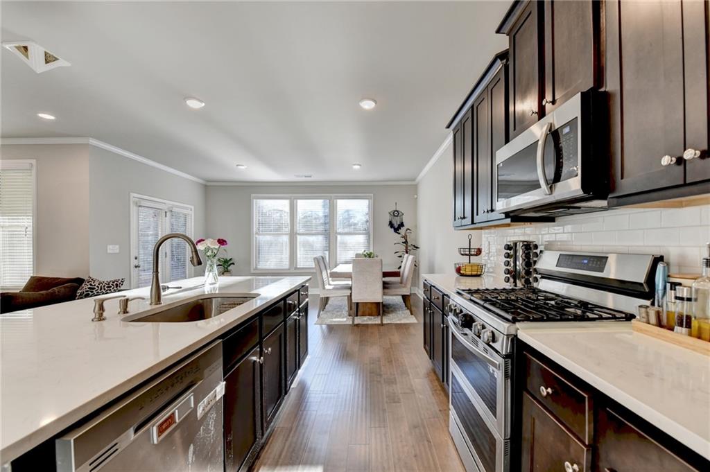 2230 Manor Pointe Drive Cumming, GA 30041 - Photo 12 of 53 a kitchen with stainless steel appliances granite countertop a sink stove and cabinets