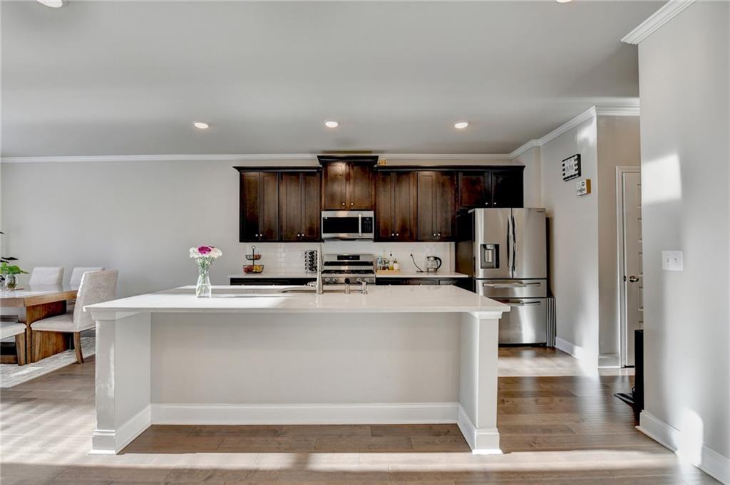 2230 Manor Pointe Drive Cumming, GA 30041 - Photo 15 of 53 a kitchen with kitchen island a stove cabinets and refrigerator