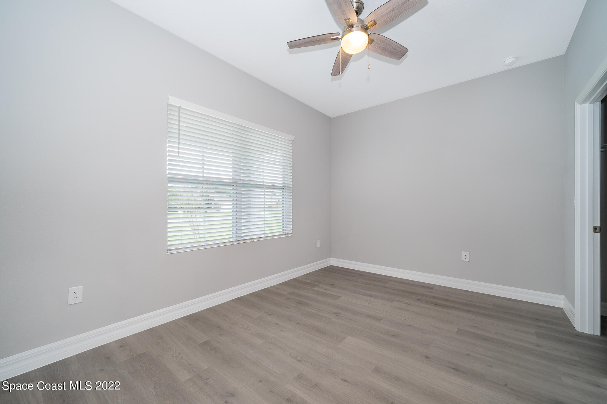 214 Gordon Road Northwest Palm Bay, FL 32907 - Photo 15 of 19 a view of an empty room with wooden floor and a window