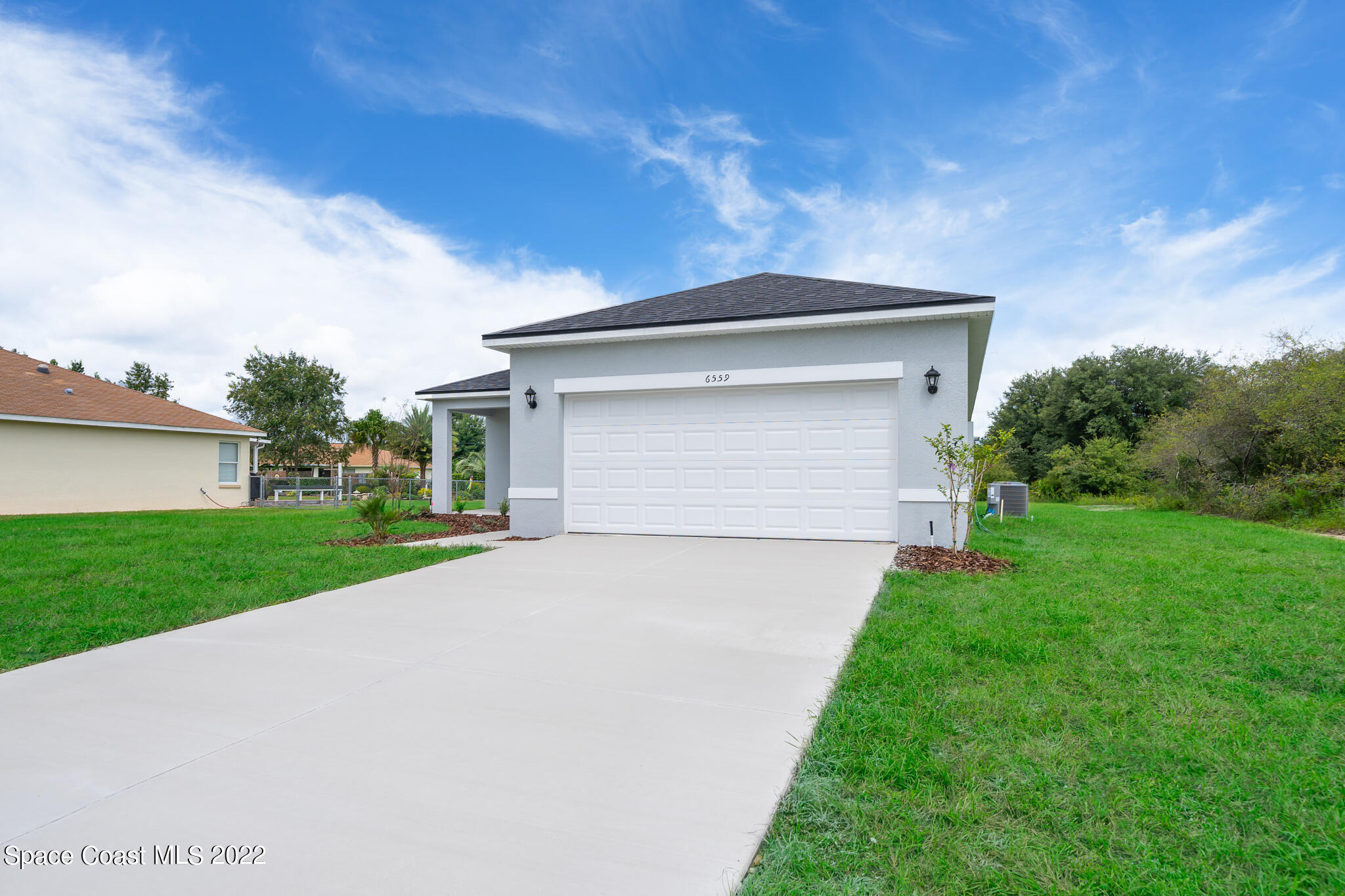 214 Gordon Road Northwest Palm Bay, FL 32907 - Photo 3 of 19 a front view of a house with a yard and garage