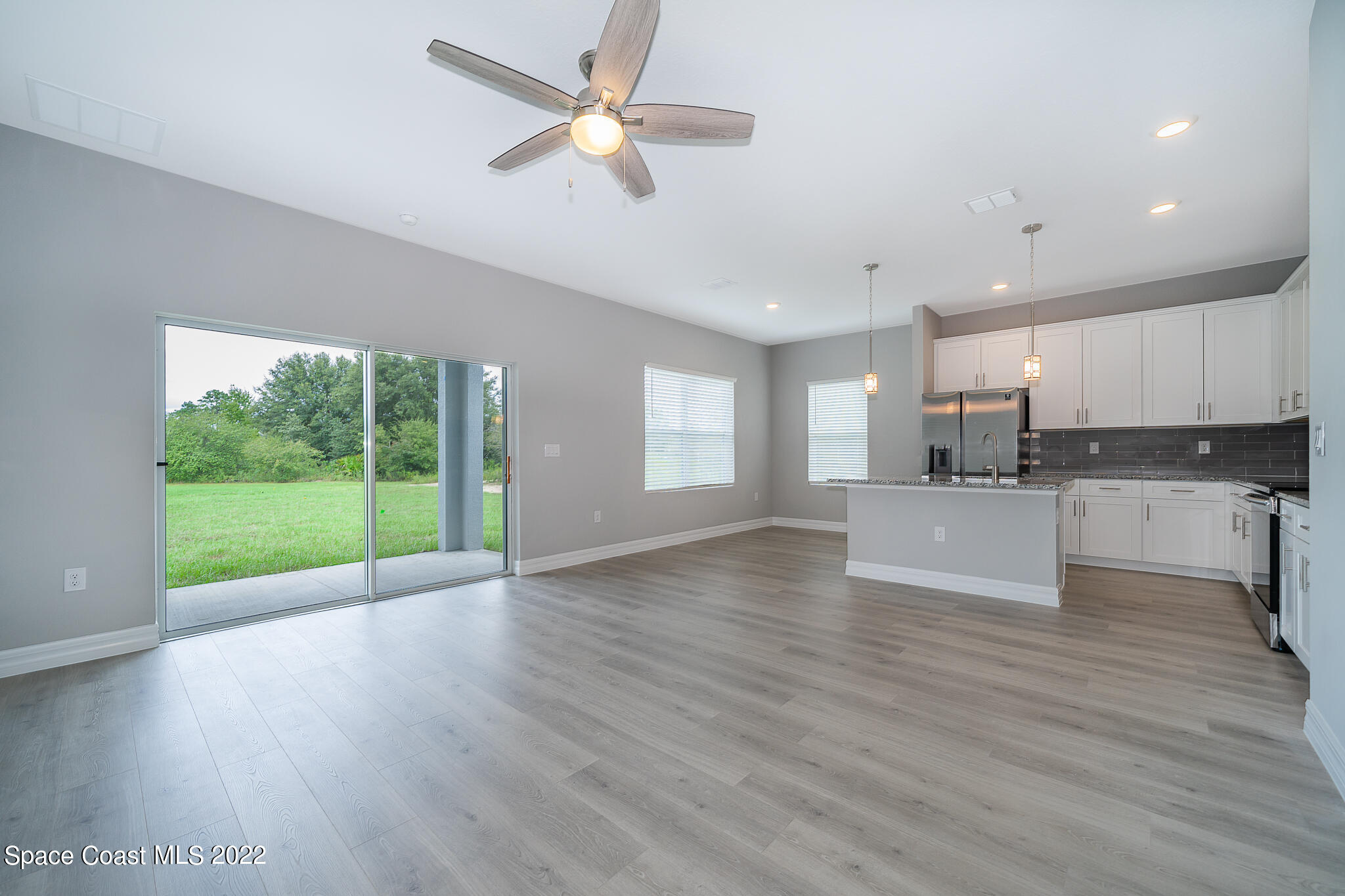 214 Gordon Road Northwest Palm Bay, FL 32907 - Photo 4 of 19 a view of kitchen with refrigerator and wooden floor
