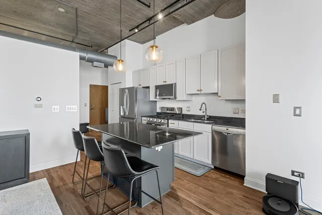 a kitchen with stainless steel appliances granite countertop a white cabinets and a refrigerator