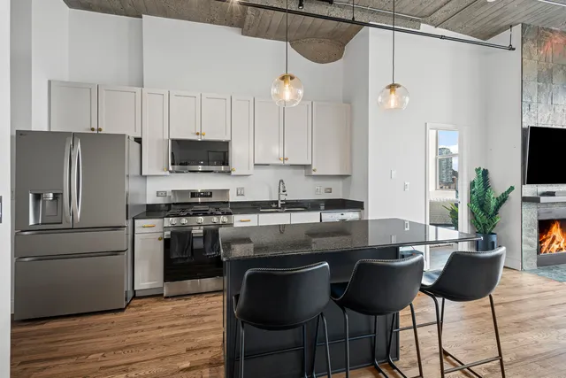 a kitchen with stainless steel appliances granite countertop a sink and a refrigerator