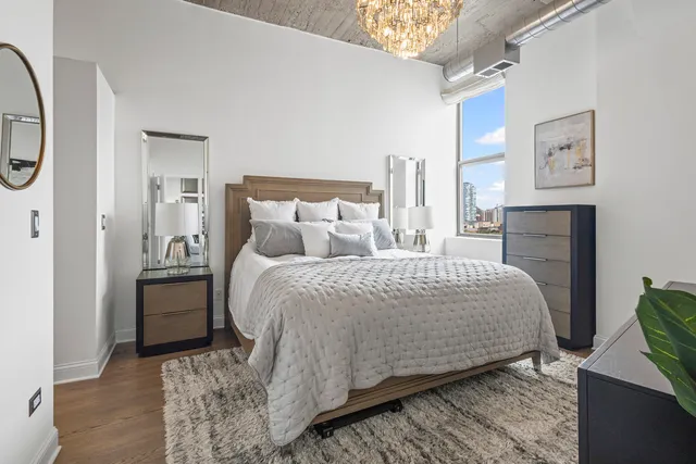 a bedroom with a bed and a chandelier
