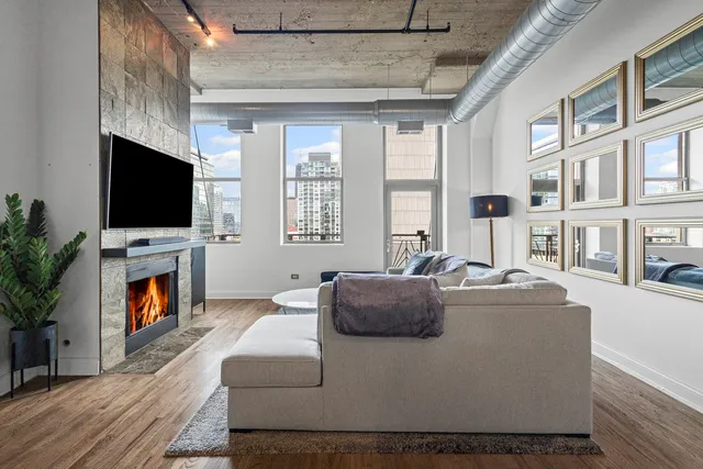 a living room with furniture a flat screen tv and a fireplace