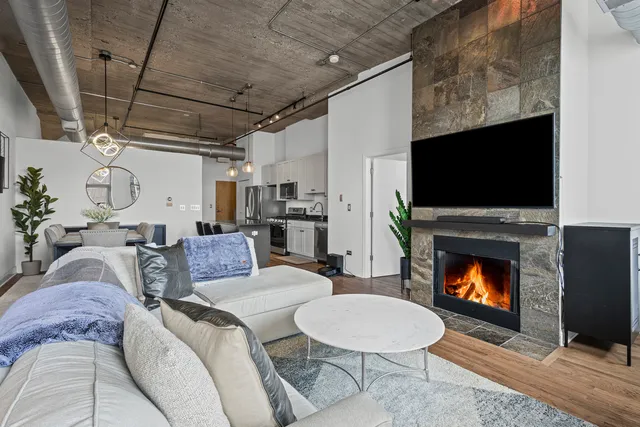 a living room with furniture a flat screen tv and a fireplace
