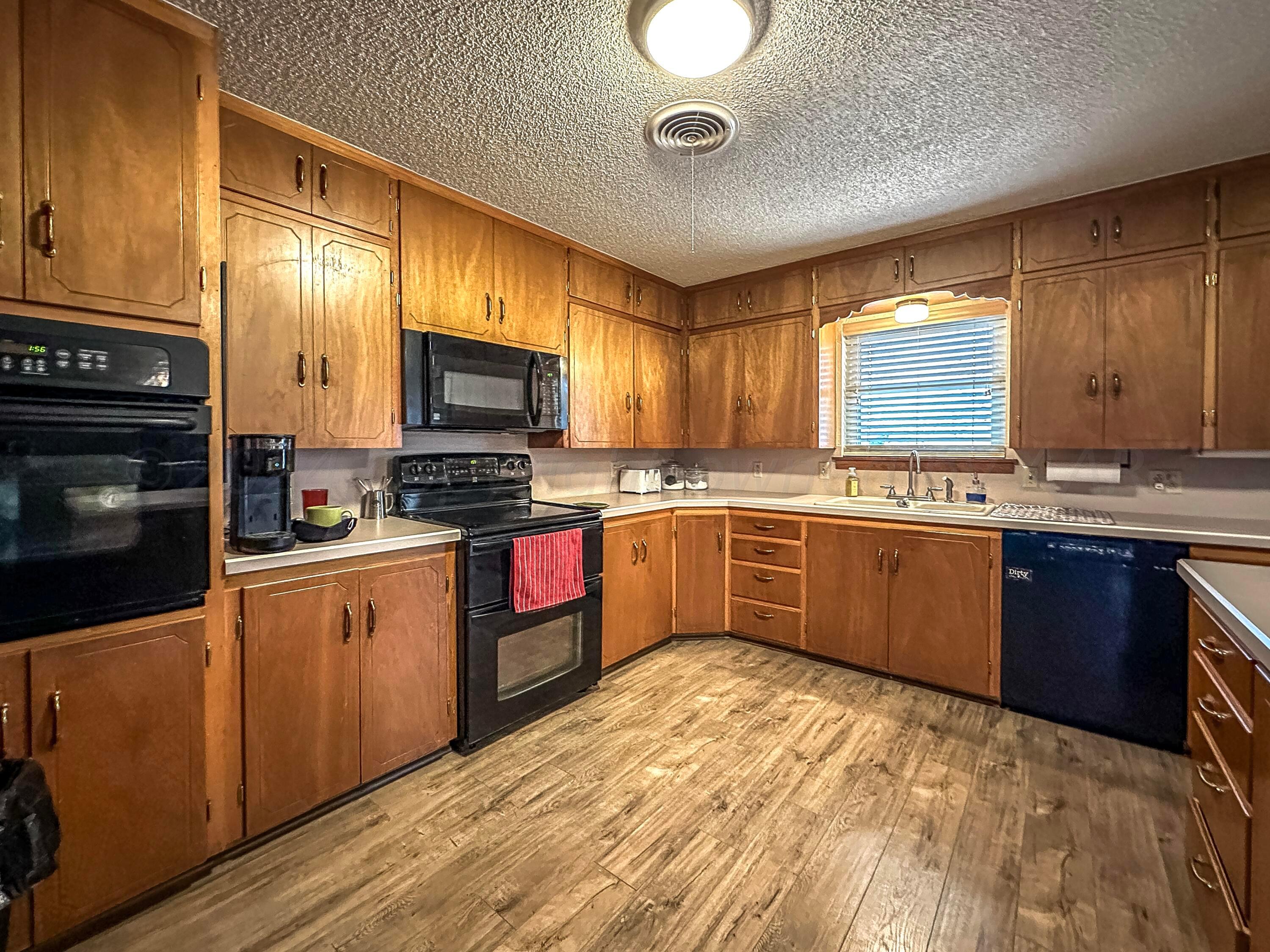 1404 Primrose Lane Borger, TX 79007 - Photo 11 of 27 a kitchen with stainless steel appliances granite countertop wooden cabinets a stove top oven a sink and dishwasher