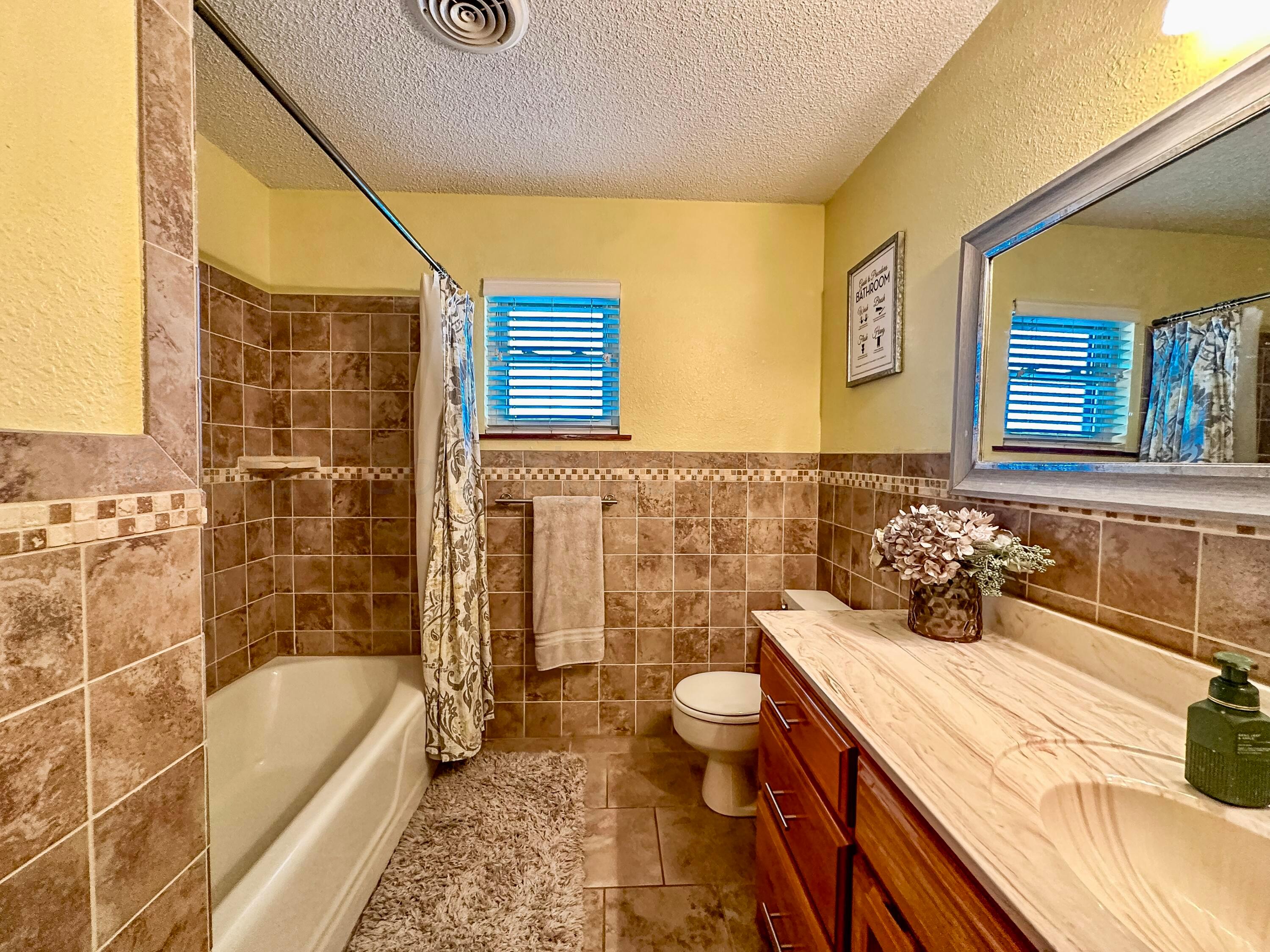 1404 Primrose Lane Borger, TX 79007 - Photo 16 of 27 a bathroom with a granite countertop sink and a bathtub
