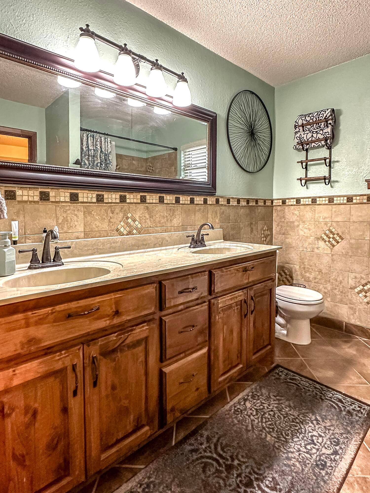 1404 Primrose Lane Borger, TX 79007 - Photo 18 of 27 a bathroom with a toilet a sink and a mirror