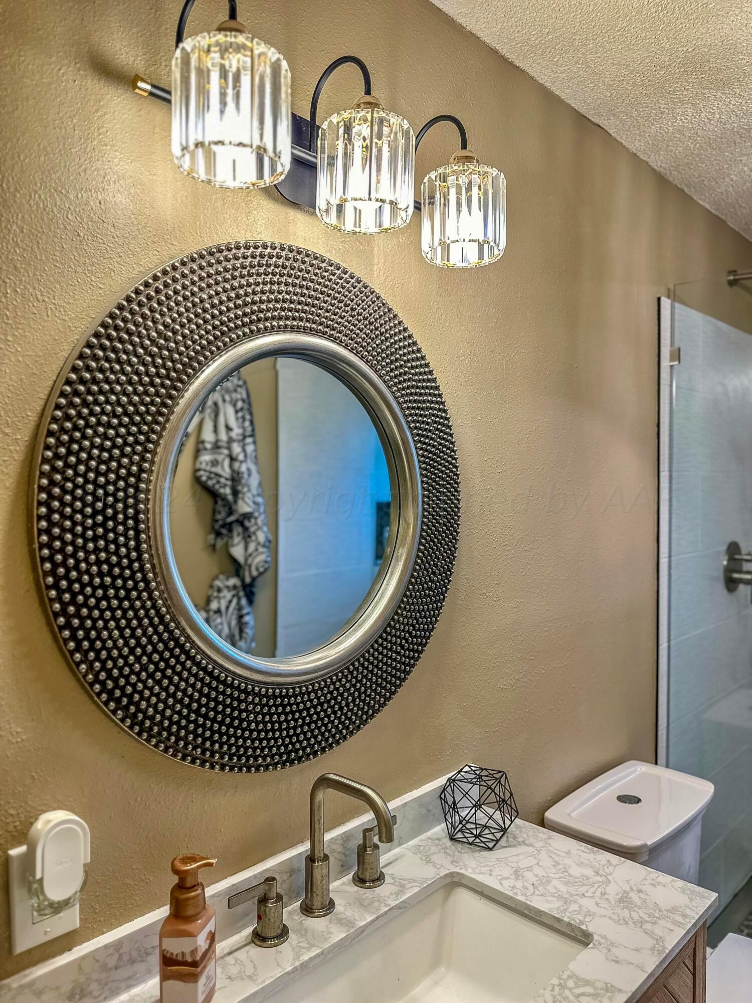 1404 Primrose Lane Borger, TX 79007 - Photo 9 of 27 a bathroom with a sink a mirror and bathtub