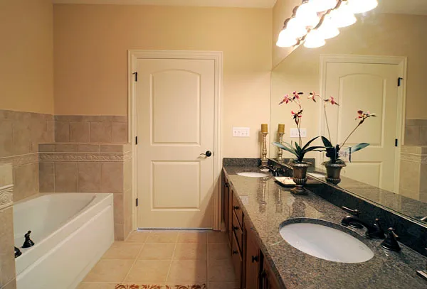 a bathroom with a granite countertop sink a mirror and a bathtub