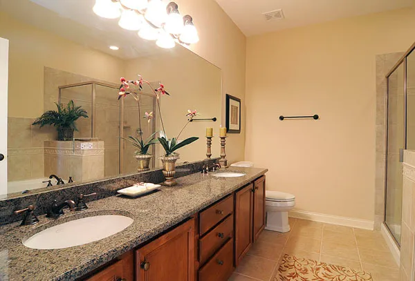 a bathroom with a granite countertop sink a toilet and a mirror