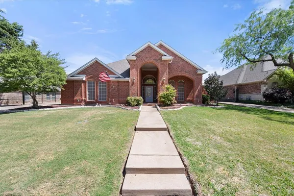 a front view of a house with a yard and trees