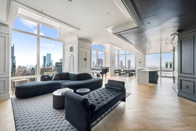 a living room with furniture kitchen view and a large window