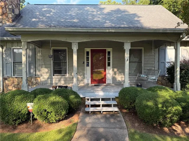a front view of a house with a garden and plants