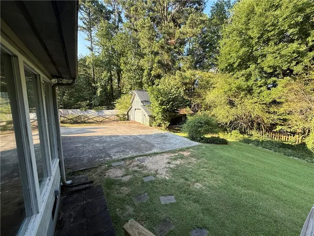 a view of a house with a wooden deck and a yard