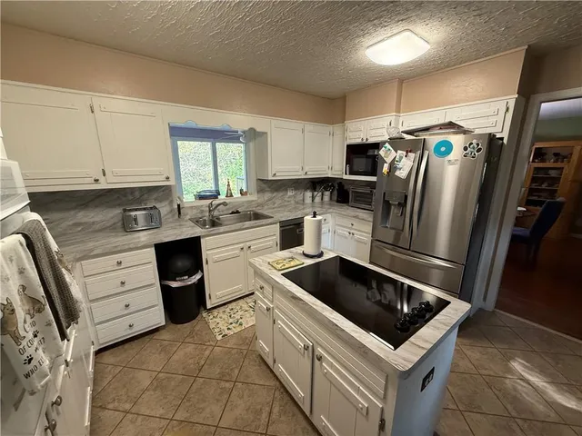 a kitchen with stainless steel appliances granite countertop a sink and a stove