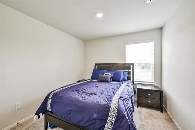 a bed sitting in a bedroom next to a window