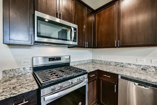 a kitchen with granite countertop a stove and a microwave