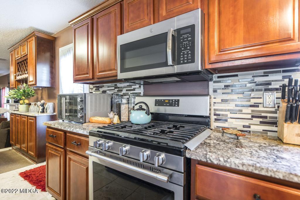 825 Kohl Drive McDonough, GA 30253 - Photo 13 of 59 a kitchen with stainless steel appliances granite countertop a stove and a microwave