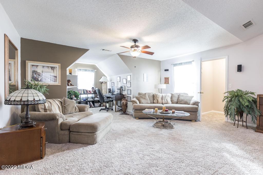 825 Kohl Drive McDonough, GA 30253 - Photo 36 of 59 a living room with furniture and a chandelier