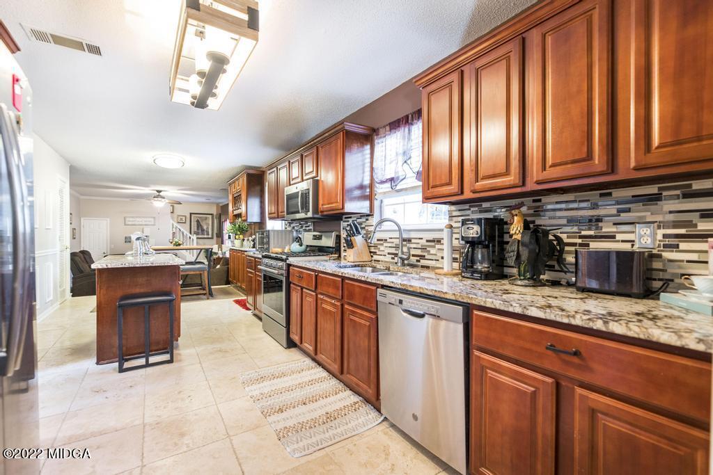 825 Kohl Drive McDonough, GA 30253 - Photo 10 of 59 a kitchen with stainless steel appliances granite countertop wooden cabinets a refrigerator and a sink