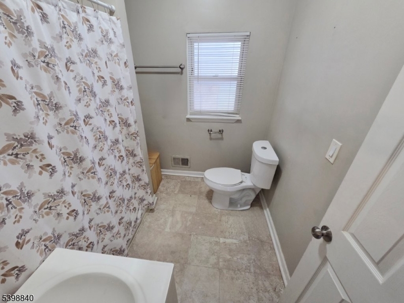 541 Fulton Street Elizabeth Port, NJ 07206 - Photo 12 of 14 a bathroom with a toilet and a shower curtain