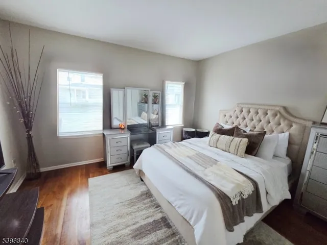a bedroom with a bed a mirror and wooden floor