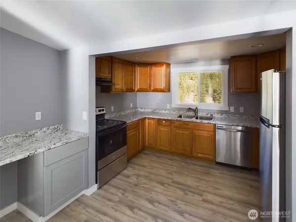 a kitchen with a sink cabinets and wooden floor