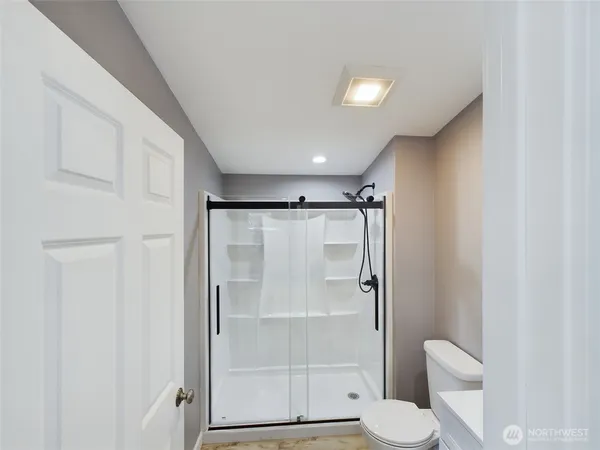 a bathroom with a shower a toilet and a sink