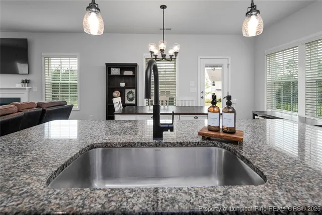 a kitchen with kitchen island granite countertop a sink and a large window