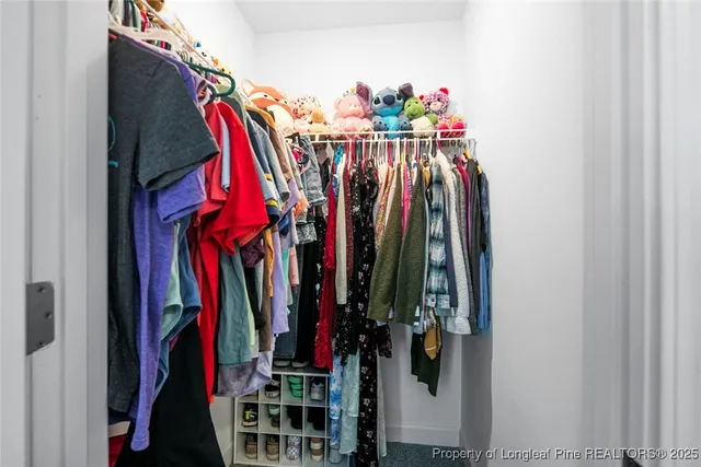 a view of walk in closet with clothes