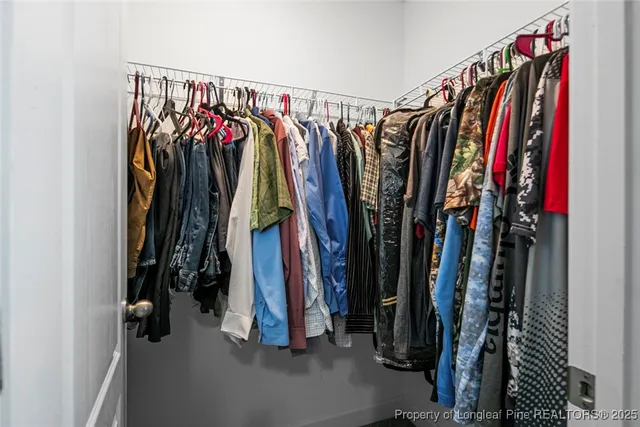 a view of walk in closet with clothes