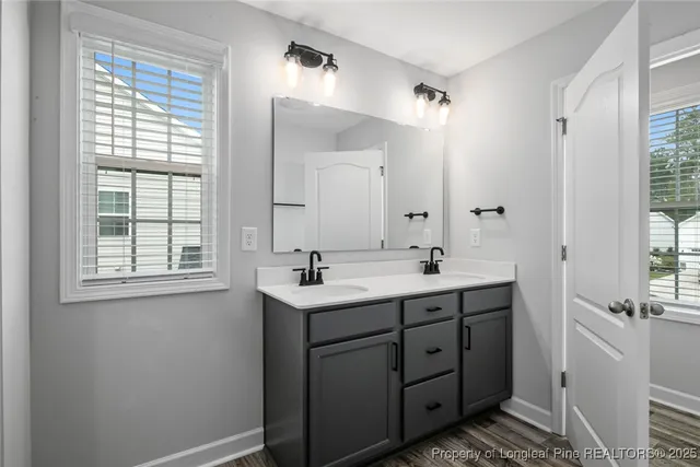 a bathroom with a double vanity sink a mirror and a bathtub
