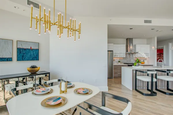 a kitchen with stainless steel appliances granite countertop a dining table and chairs