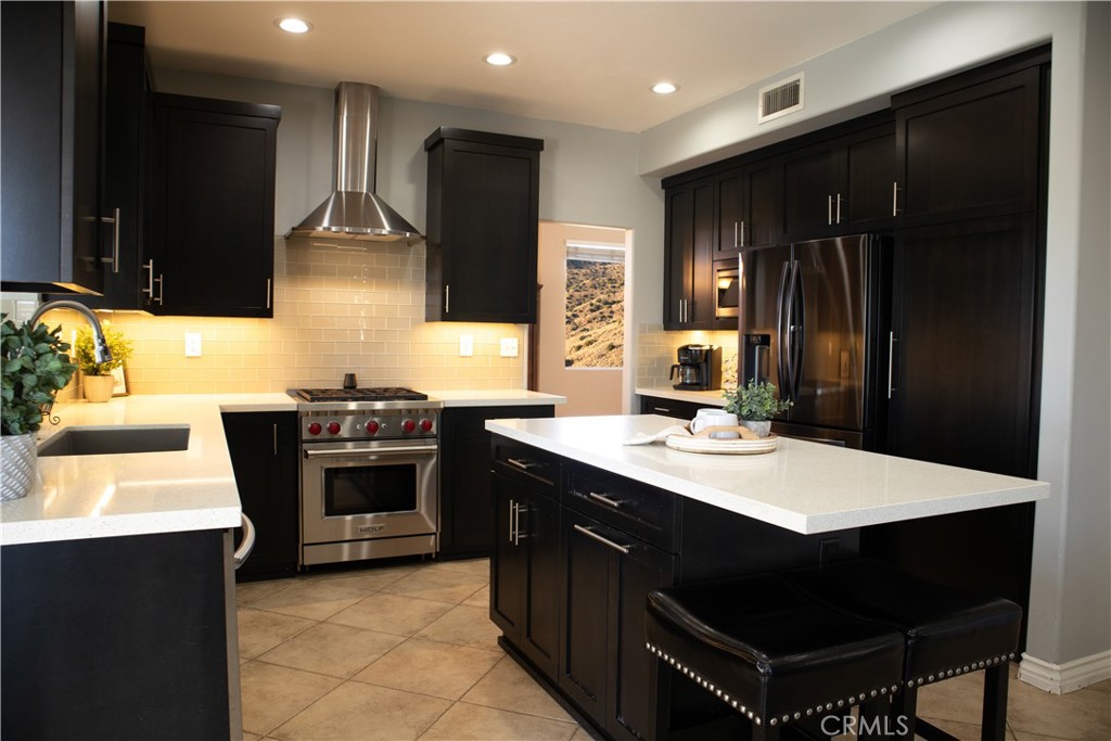 28469 Via Joyce Drive Saugus, CA 91350 - Photo 15 of 23 a kitchen with stainless steel appliances a stove a sink and a refrigerator