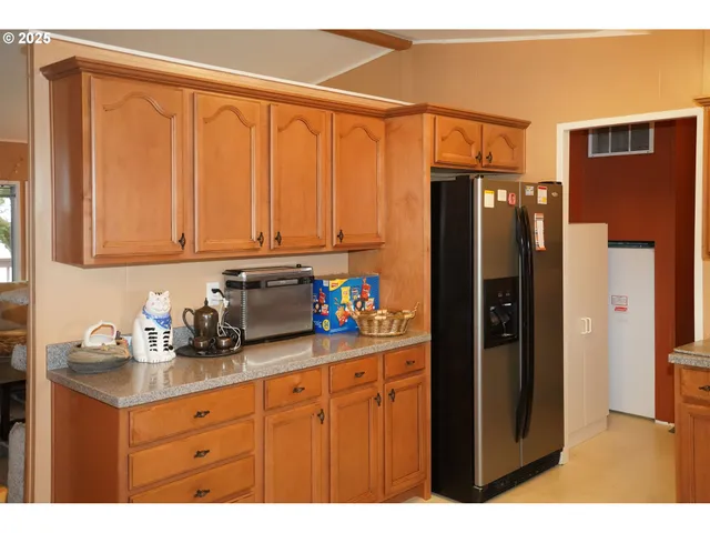a kitchen with stainless steel appliances granite countertop a refrigerator and cabinets