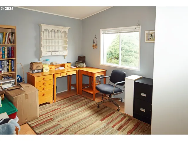a view of a workspace with furniture and a window
