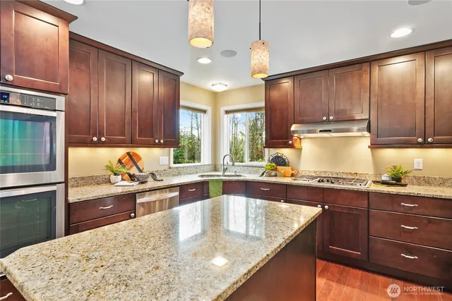 a kitchen with kitchen island granite countertop a sink window and cabinets