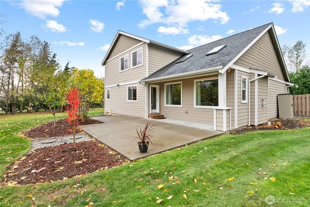 a front view of a house with a yard and trees
