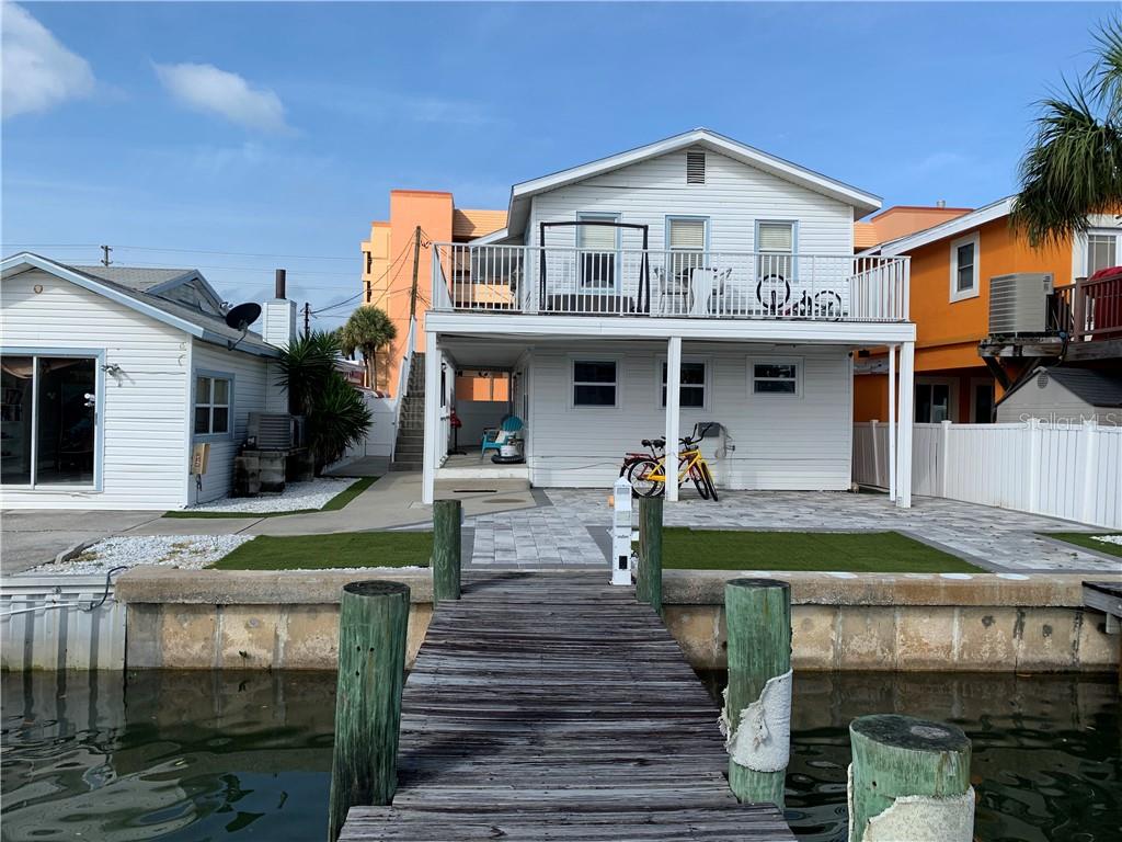 a front view of a house with a garden and plants