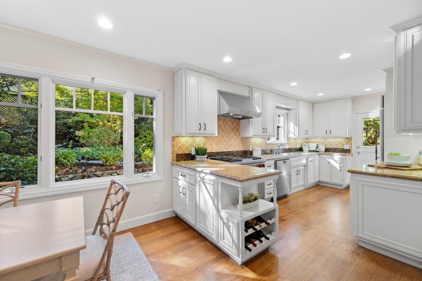 425 Dorchester Road San Mateo, CA 94402 - Photo 15 of 61 a kitchen with a stove a sink a kitchen island with a dining table and chairs