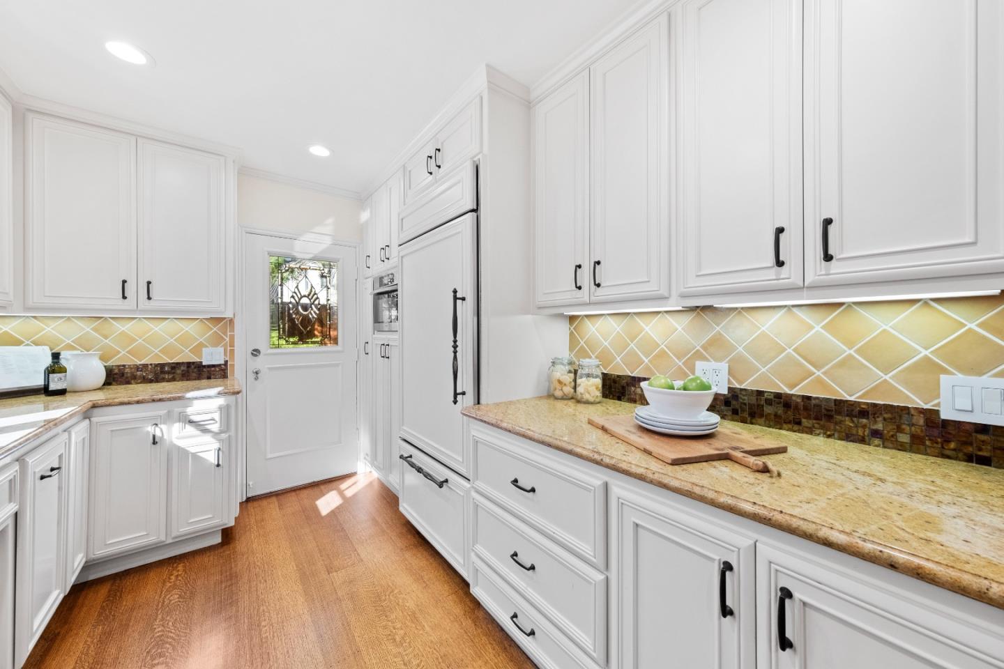 425 Dorchester Road San Mateo, CA 94402 - Photo 18 of 61 a kitchen with granite countertop white cabinets and white appliances