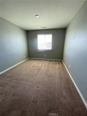 an empty room with a window and a fireplace