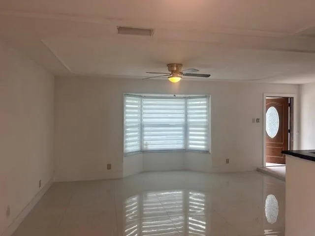 a view of an empty room with window and cabinet