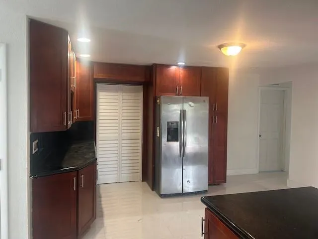 a kitchen with granite countertop a refrigerator and a sink