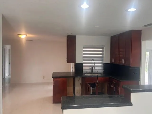 a kitchen with granite countertop cabinets and window
