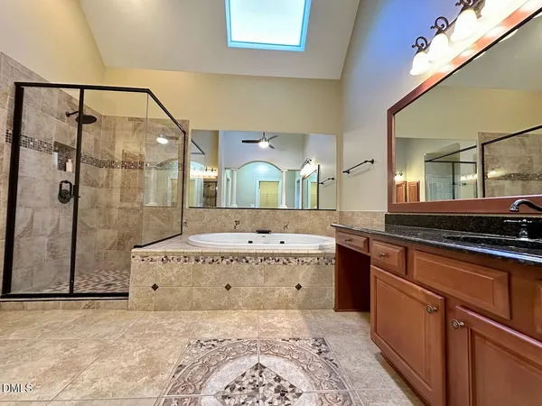 a spacious bathroom with a granite countertop sink a mirror and shower