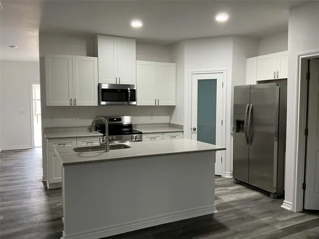 a kitchen with kitchen island a sink and refrigerator
