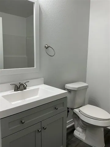 a bathroom with a sink mirror vanity and toilet